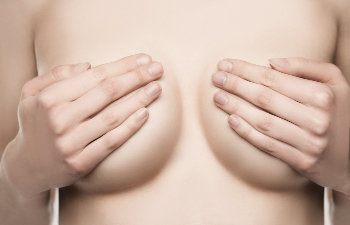woman covers her breasts with her hands